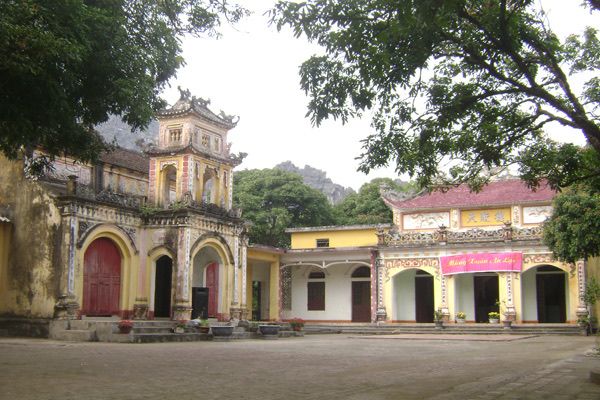 Sân chùa Tiên lát gạch, bên trái là gác chuông nhiều tầng mái với cửa cuốn sơn đỏ, bên phải là dãy nhà mái ngói, phía sau là núi đá