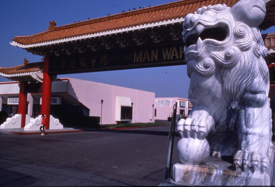 Cổng mái ngói đỏ kiểu Á Đông của một khu chợ ở Little Saigon, bên cạnh tượng sư tử đá trắng